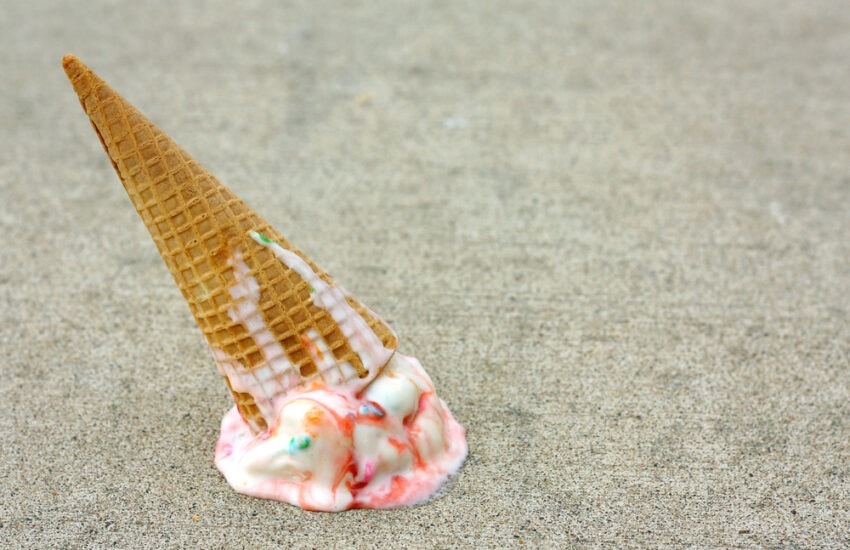 Stock image: A colorful dropped ice cream cone melts on the sidewalk.