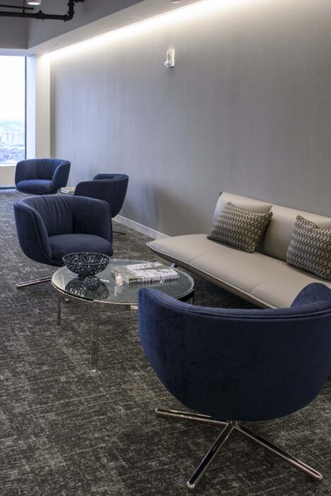 Seating in the reception area of the new Wilson Sonsini Boston office: a gray couch and blue chairs.