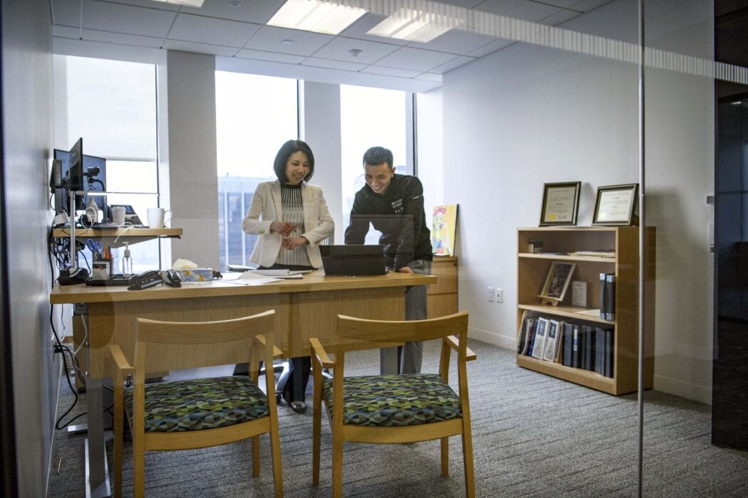 A female attorney and a male patent agent working together in a lawyer's office at Wilson Sonsini in Boston.