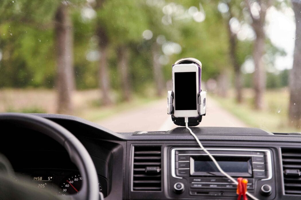 cell phone mounted to the top of the dashboard of a car